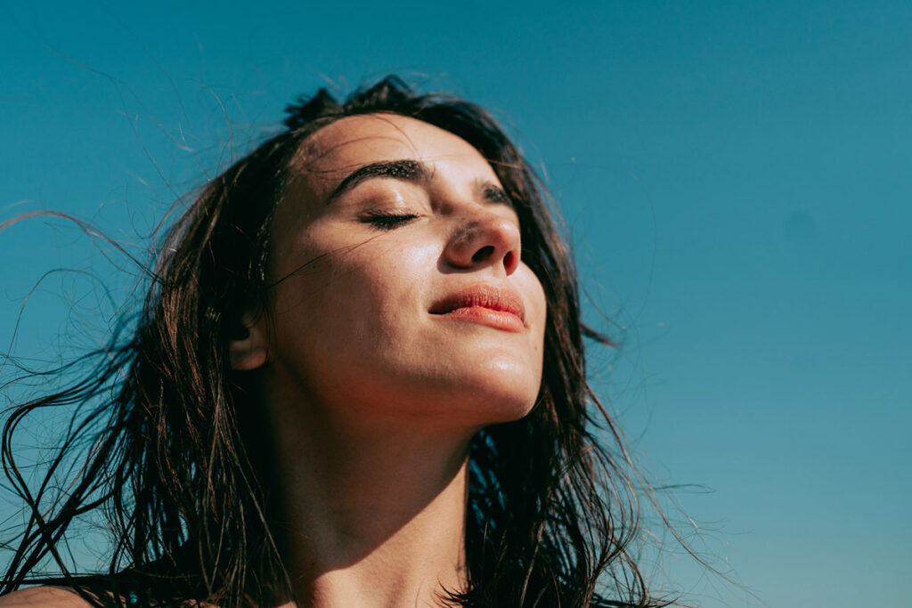 Self-portrait photo of a young woman at the beach.