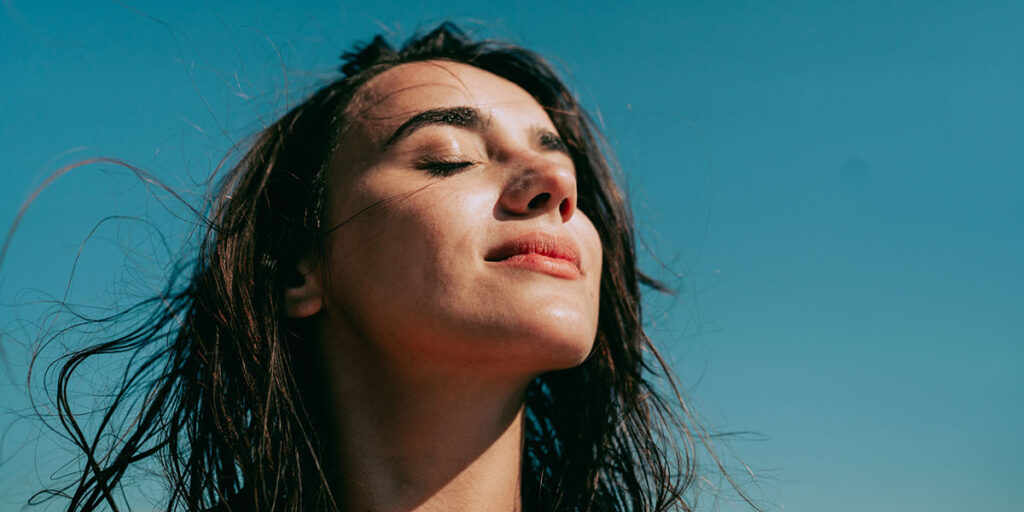 Self-portrait photo of a young woman at the beach.